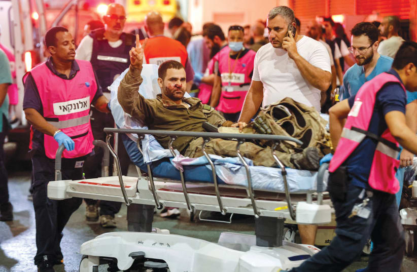  A wounded Israeli officer arrives at a hospital in Ashkelon on October 7. (photo credit: AMIR COHEN/REUTERS)
