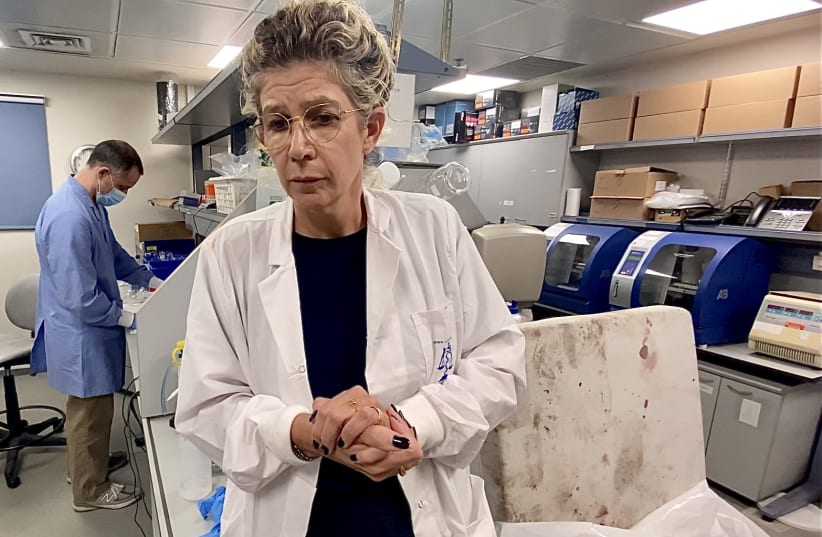  Dr. Nurit Bublil, head of the DNA laboratory in Israel’s National Center for Forensic Medicine, stands next to a blood-stained baby's mattress, Oct. 16, 2023 (photo credit: Aaron Poris/The Media Line)