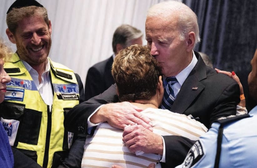  POLICEMAN EVYATAR EDRI looks on, as US President Joe Biden hugs his mother, Rachel Edri, who was held hostage by Hamas, while meeting with people affected by this month’s Hamas attack on Israel, Wednesday in Tel Aviv. (photo credit: BRENDAN SMIALOWSKI/AFP via Getty Images)