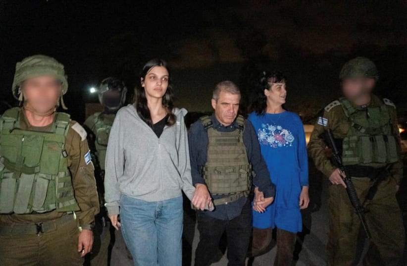  Judith Tai Raanan and her daughter Natalie Shoshana Raanan, US citizens who were taken as hostages by Palestinian Hamas militants, walk while holding hands with Brig.-Gen. (Ret.) Gal Hirsch, Israel's Coordinator for the Captives and Missing, after they were released by the militants. (photo credit: Government of Israel/Handout via REUTERS)
