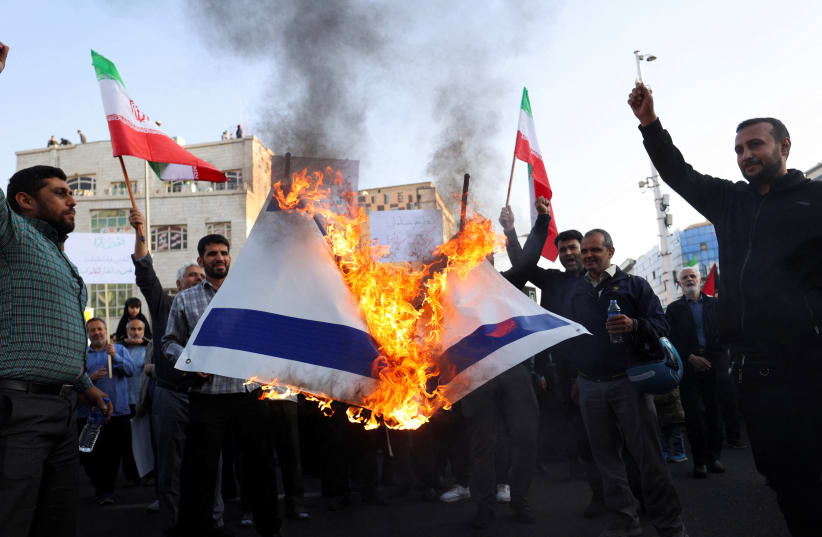  Protesters burn the Israeli flag during an anti-Israel protest in Tehran, Iran, October 18, 2023 (photo credit: Majid Asgaripour/ WANA via Reuters)