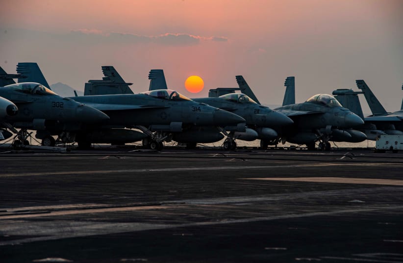  Sunset is seen behind fighter jets on the flight deck of United States Navy aircraft carrier USS Dwight D. Eisenhower (CVN 69) as it transits the Suez Canal in this picture taken April 2, 2021 and released by US Navy on April 3, 2021. (photo credit: Joseph T. Miller/US Navy/Handout)