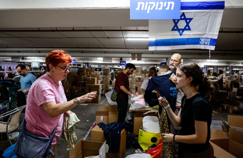  Volunteers sort boxes of donated humanitarian supplies at a logistical centre to support those impacted by the deadly infiltration by Hamas terrorists from the Gaza Strip, in Tel Aviv, Israel October 17, 2023. (photo credit: REUTERS/AMMAR AWAD)