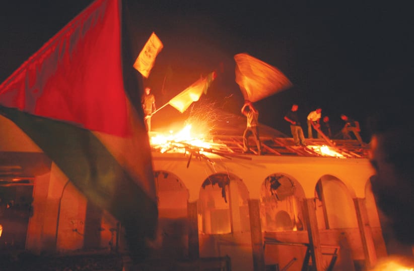  PALESTINIANS BURN a synagogue in the evacuated Israeli settlement of Netzarim in the northern Gaza Strip, September 2005.  (photo credit: YANNIS BEHRAKIS/REUTERS)