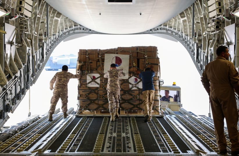  Qatari Amiri Air Force crew load food and medical aid to their cargo plane from the Qatar Fund for Development headed to Egypt for Gaza, at Al Udeid Air Base, Doha, Qatar, October 16, 2023. (photo credit: QATAR NEWS AGENCY/HANDOUT VIA REUTERS)
