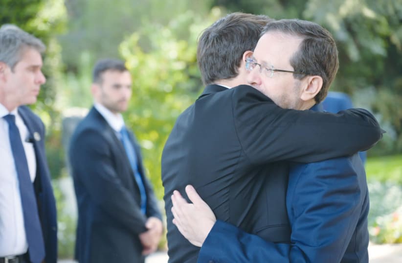  FRENCH PRESIDENT Emmanuel Macron and President Isaac Herzog embrace in friendship and solidarity. (photo credit: AMOS BEN GERSHOM/GPO)
