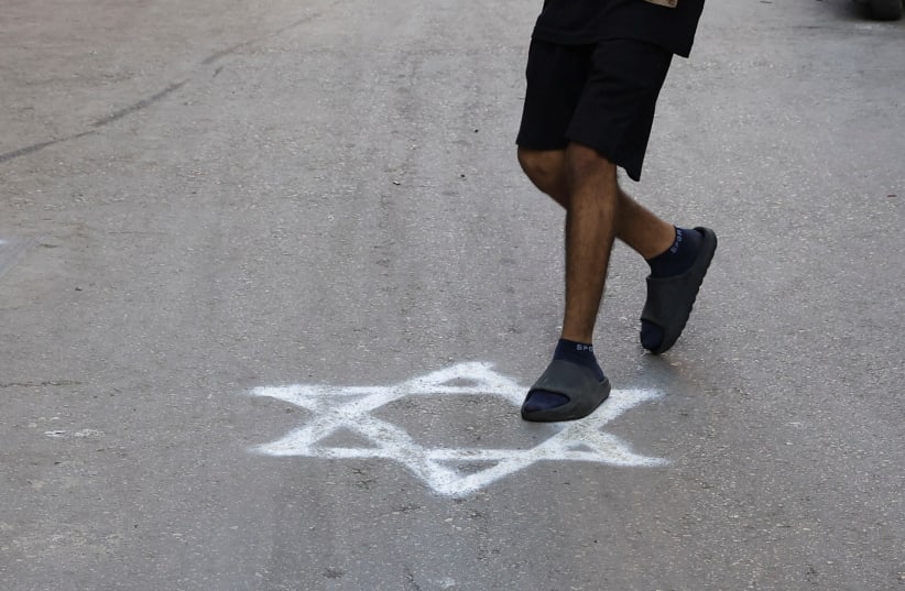  A person steps on a graffiti of the Star of David sprayed on a pavement in Bourj al-Barajneh Refugee Camp in Beirut, Lebanon, October 25, 2023 (photo credit: REUTERS/AMR ALFIKY)