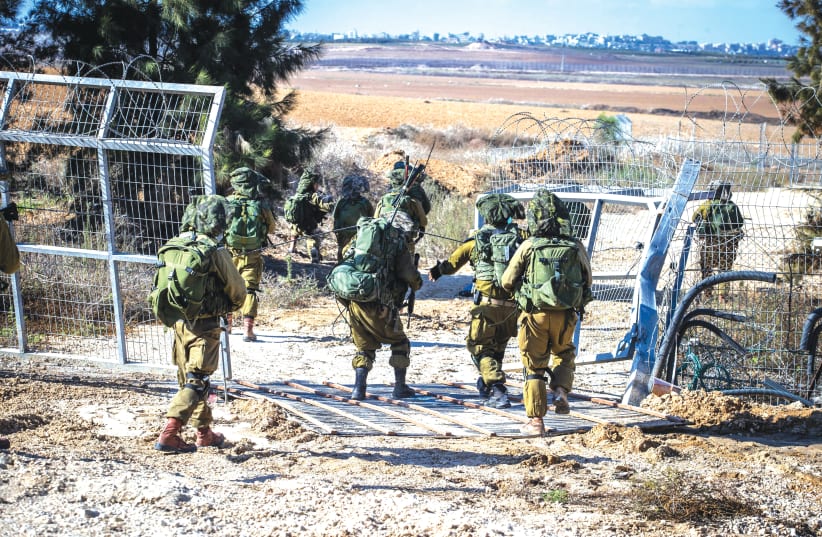  IDF SOLDIERS take up a position at the fence of Kibbutz Kfar Aza, near the Israel-Gaza border. (photo credit: OREN BEN HAKOON/FLASH90)