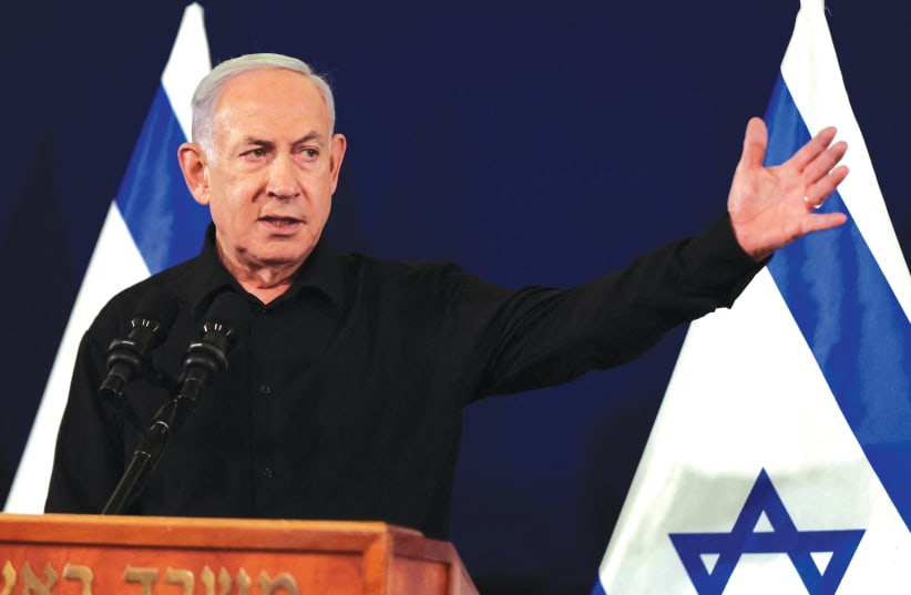  PRIME MINISTER Benjamin Netanyahu holds a news conference in Tel Aviv, last Saturday night. Replacing a suit, white shirt, and tie with a black open-necked shirt is a political act, meant to convey a message, according to the writer.  (photo credit: Abir Sultan/Reuters)