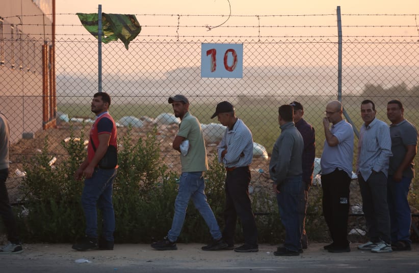  Palestinian workers stand in line at the reopened Erez crossing to Israel, after Israel ends a ban on workers from Gaza, in Gaza City, on September 28, 2023. (photo credit: ATIA MOHAMMED/FLASH90)