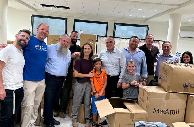 (from L-R): Head of the Gush Etzion Regional Council, Shlomo Neeman and Mayor of Efrat, Oded Revivi join Founder & CEO of Just One Chesed, Jerry Latinik and local volunteers at the Efrat emergency packaging site. (photo credit: Just One Chesed)