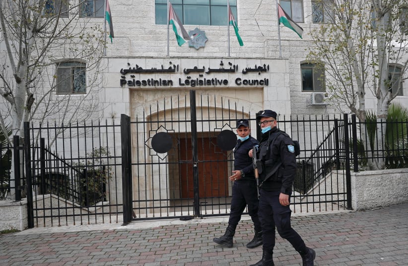   PALESTINIAN POLICEMEN guard the Palestinian Legislative Council building in Ramallah in 2021. In 2006, Hamas won the Palestinian legislative election. (photo credit: MOHAMAD TOROKMAN/REUTERS)