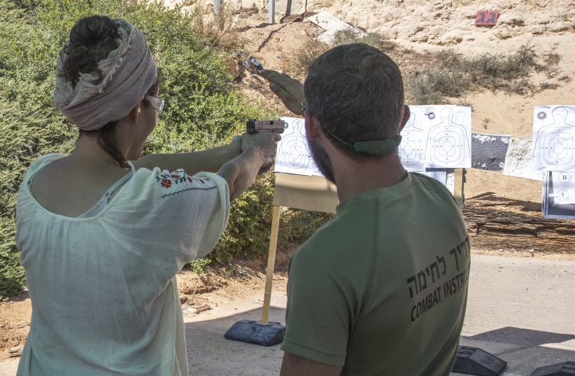  A woman is seen using a gun at Caliber 3's shooting range.  (photo credit: MARC ISRAEL SELLEM/THE JERUSALEM POST)