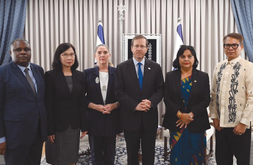  President Isaac Herzog and his wife, Michal, flanked by ambassadors of countries whose citizens are among the hostages in Hamas captivity; (from left) Alex Gabriel Kalua of Tanzania, Pannabha Chandraramya of Thailand, Kanta Rizal of Nepal, and Pedro Laylo of Philippines. (photo credit: HAIM ZACH/GPO)