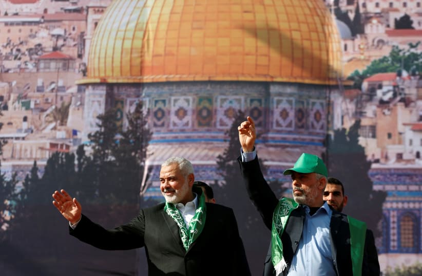 Hamas Chief Ismail Haniyeh and Gaza's Hamas Chief Yehya Al-Sinwar gesture to supporters during a rally marking the 30th anniversary of Hamas' founding, in Gaza City December 14, 2017. (photo credit: MOHAMMED SALEM/REUTERS)