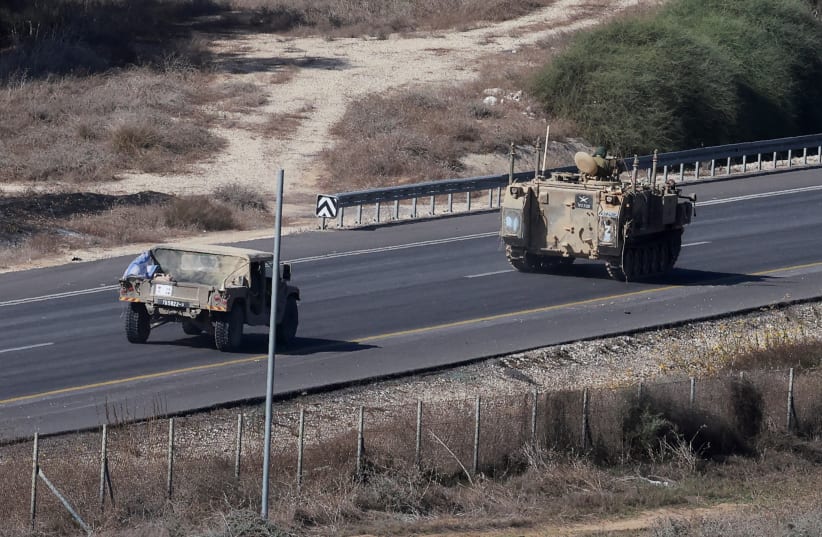  An Israeli APC and a military vehicle drive along a road, near the border between Israel and the Gaza Strip, in southern Israel, November 8, 2023 (photo credit: REUTERS/AMMAR AWAD)