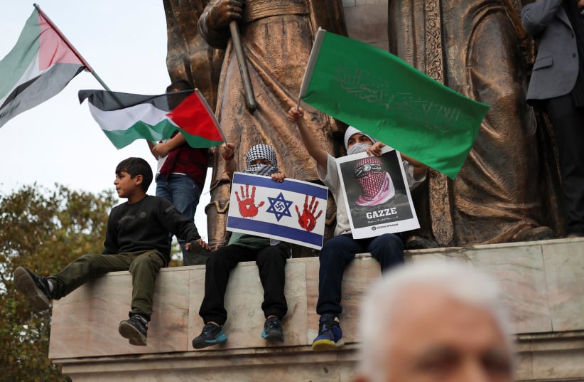  A child holds a sign depicting the Israeli flag with a swastika and bloody hand prints, as Pro-Palestinian demonstrators take part in a protest against U.S. Secretary of State Antony Blinken's visit to Turkey, amid the ongoing conflict between Israel and Palestinian Islamist group Hamas, in Istanbu (photo credit: REUTERS/MURAD SEZER)