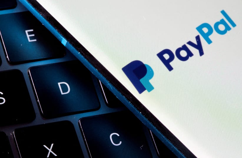  A smartphone with the PayPal logo is placed on a laptop in this illustration taken on July 14, 2021. (photo credit: REUTERS/DADO RUVIC)