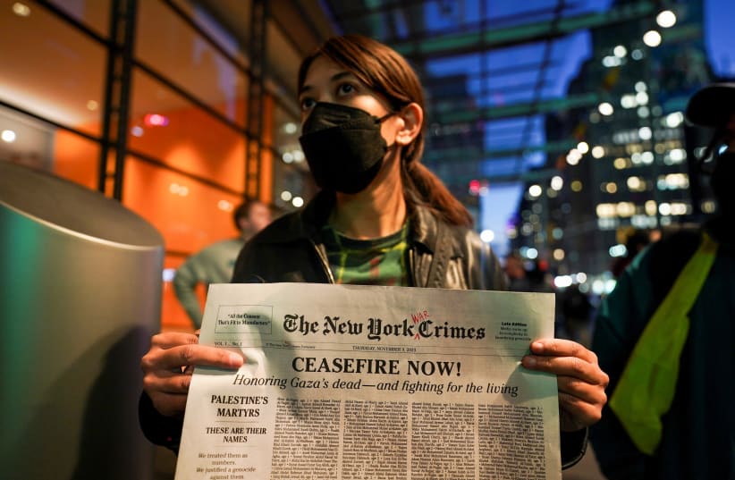  A woman holds a mock-up newspaper with a list of names of people killed in Gaza, during a rally in support of Palestinians, as the conflict between Israel and Hamas continues, outside The New York Times building in New York City, US, November 9, 2023. (photo credit: REUTERS/David Dee Delgado)