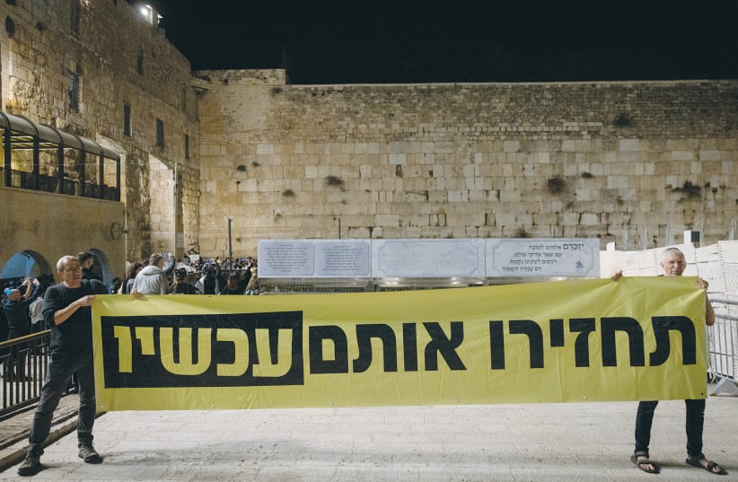 A SIGN reads ‘Return them now,’ at a ceremony and prayer at the Western Wall last week for those abducted by Hamas terrorists during the massacre.  (photo credit: Chaim Goldberg/Flash90)