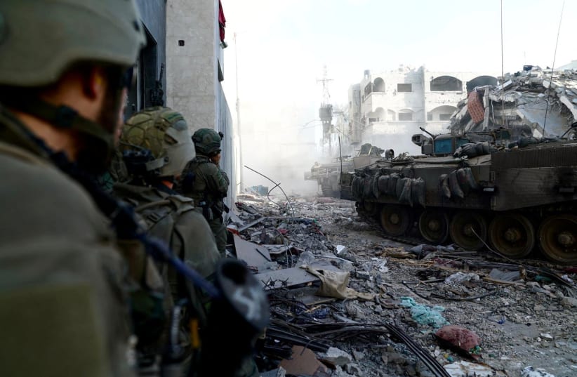  Israeli military vehicles take position, amid the ongoing ground operation of the Israeli army against Palestinian Islamist group Hamas, in the Gaza Strip as seen in a handout picture released by the Israel Defense Forces on November 12, 2023. (photo credit: Israel Defense Forces/Handout via REUTERS)