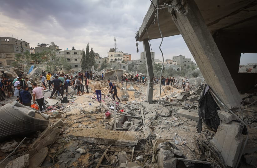  Palestinians at the rubble of a destroyed building after an Israeli airstrike in Khan Yunis, in the southern Gaza Strip, on November 12, 2023 (photo credit: ATIA MOHAMMED/FLASH90)