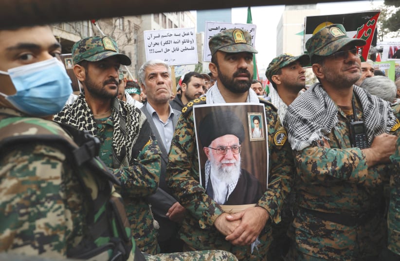 A member of the Iranian police holds a picture of Iran's Supreme Leader Ayatollah Ali Khamenei on the 44th anniversary of the US expulsion from Iran, earlier this month, in Tehran. (photo credit: WEST ASIA NEWS AGENCY/REUTERS)