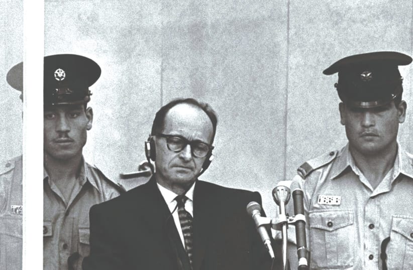  POLICE OFFICERS flank Adolf Eichmann at his trial in Jerusalem, in 1961. High-ranking Hamas figures should be subjected to a transparent and widely publicized trial, similar in style to the Eichmann trial, the writer argues.  (photo credit: REUTERS)