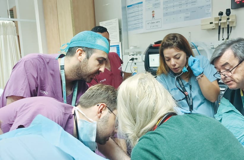  THE WRITER (second from right) is part of the medical team treating a patient in the trauma room of Soroka Hospital’s ER. (photo credit: Soroka Hospital)