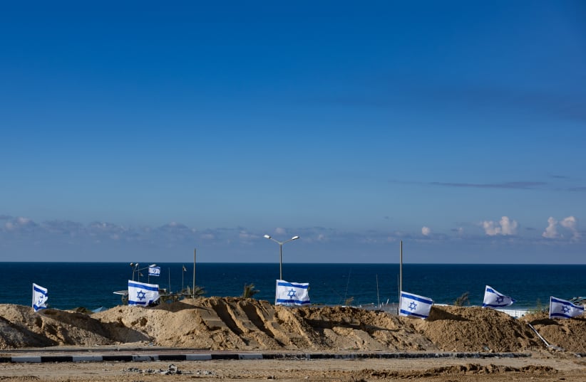  Israeli flags at the beach in the northern Gaza Strip, during an Israeli military operation in the Gaza Strip, November 16, 2023.  (photo credit: YONATAN SINDEL/FLASH90)
