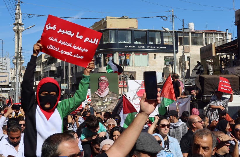  Demonstrators carry flags and banners during a protest in support of Palestinians in Gaza, amid the ongoing conflict between Israel and the Palestinian Islamist group Hamas, in Amman, Jordan November 10, 2023.  (photo credit: REUTERS/JEHAD SHELBAK)