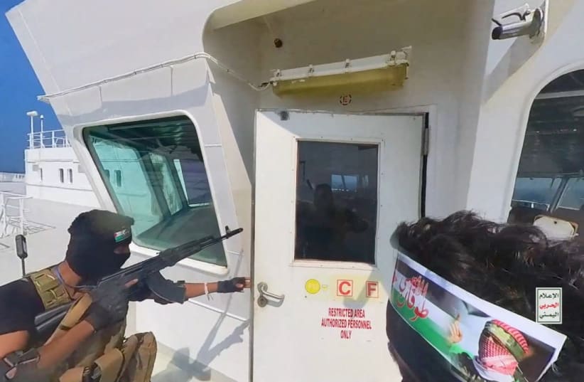 Houthi terrorists open the door of the cockpit on the ship's deck in the Red Sea in this photo released November 20, 2023 (photo credit: Houthi Military Media/Handout via REUTERS)