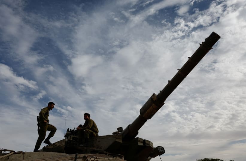  IDF soldiers rest on a tank, amid the ongoing conflict between Israel and the Palestinian group Hamas, near Israel's border with Gaza in southern Israel, November 22, 2023. (photo credit: AMIR COHEN/REUTERS)
