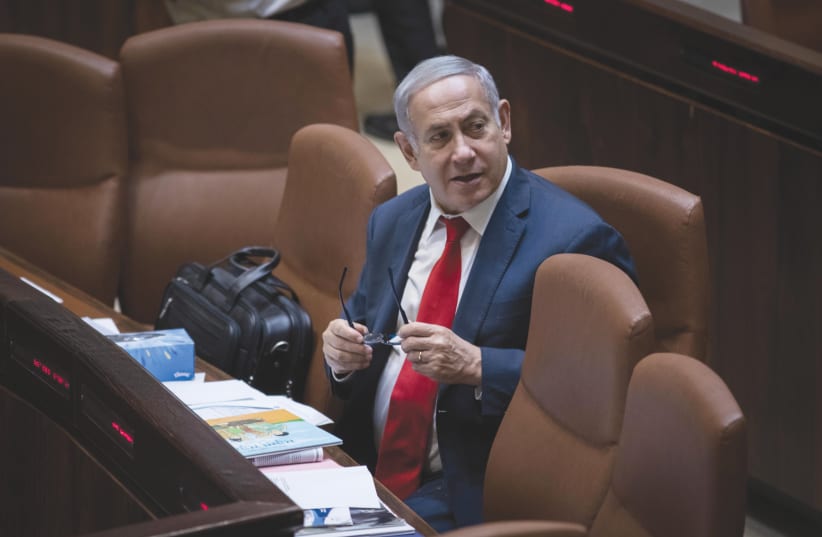  Prime Minister Benjamin Netanyahu sits in the Knesset plenum ahead of the vote on passing the Nation-State Law, in 2018. (photo credit: HADAS PARUSH/FLASH90)