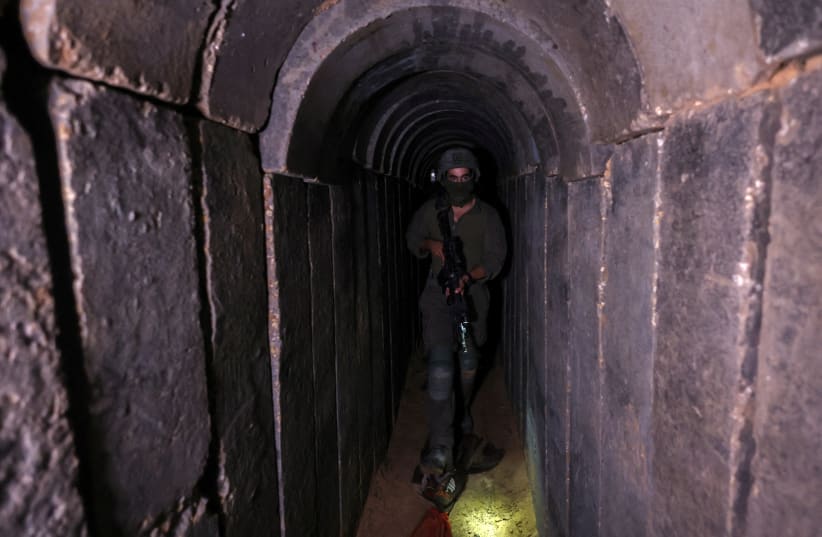  An Israeli soldier walks through a tunnel underneath Al Shifa Hospital in Gaza City, November 22, 2023 (photo credit: RONEN ZVULUN/REUTERS)