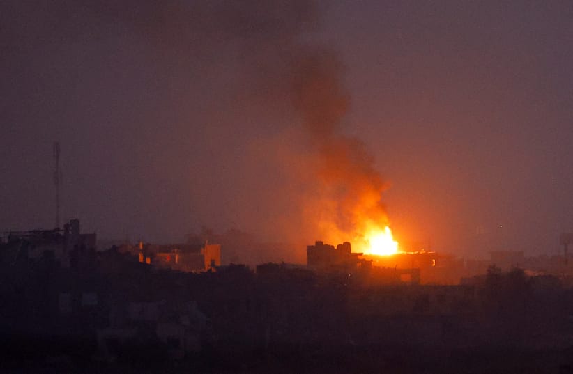 Fire burns after an explosion in north Gaza, as seen from southern Israel, amid the ongoing conflict between Israel and the Palestinian group Hamas, November 23, 2023 (photo credit: REUTERS/ALEXANDER ERMOCHENKO)