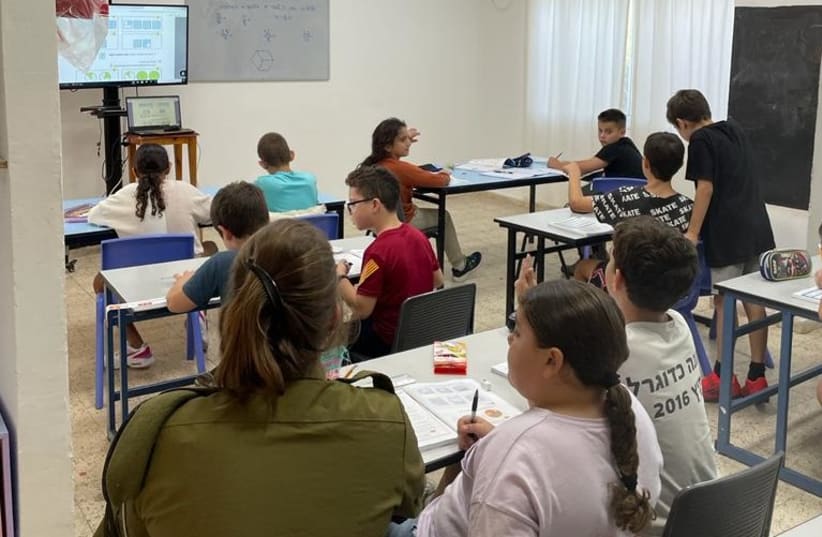  An IDF soldier accompanies students in class to help bolster their learning (photo credit: IDF SPOKESPERSON'S UNIT)