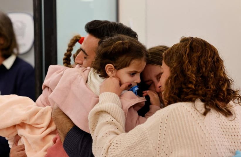 Aviv Asher, 2,5-year-old, her sister Raz Asher, 4,5-year-old, and mother Doron, react as they meet with Yoni, Raz and Aviv's father and Doron's husband after they returned to Israel to the designated complex at the Schneider Children's Medical Center, during a temporary truce between Hamas and Israe (photo credit: Schneider Children's Medical Center Spokesperson/Handout via REUTERS)