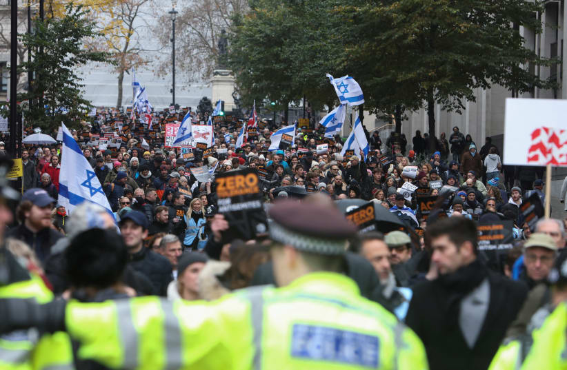 Demonstrators wave Israeli flags at a march against the rise of antisemitism in the UK, during a temporary truce between the Palestinian terrorist group Hamas and Israel, in London, Britain November 26, 2023. (photo credit: Susannah Ireland/Reuters)