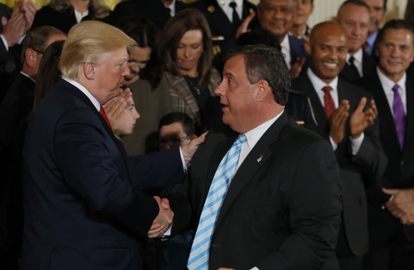  US President Donald Trump greets New Jersey Governor Chris Christie (R) after speaking about administration plans to combat the nation's opioid crisis in the East Room of the White House in Washington, US, October 26, 2017 (photo credit: Carlos Barria/Reuters)