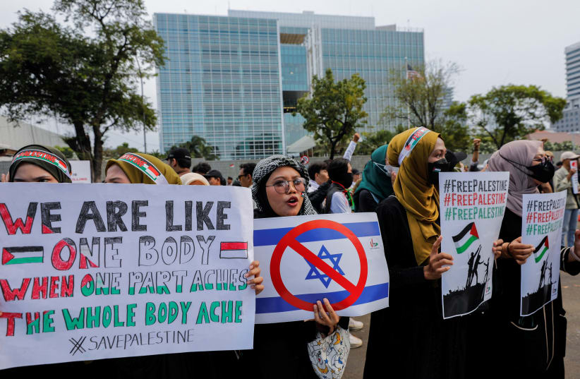  Pro-Palestinian supporters carrying placards take part in a rally, amid the ongoing conflict between Israel and the Palestinian Islamist group Hamas, outside the U.S. embassy in Jakarta, Indonesia, October 20, 2023. (photo credit: REUTERS/WILLY KURNIAWAN)