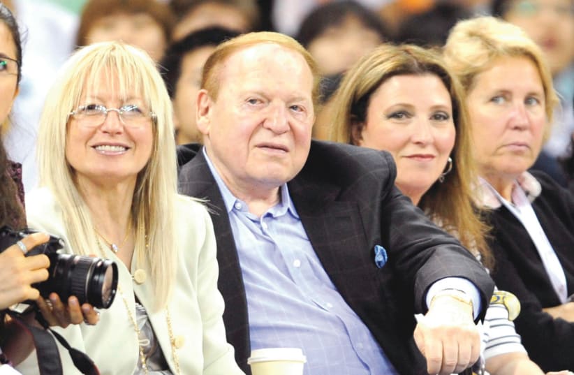  Miriam Adelson with late husband Sheldon Adelson at a basketball game (photo credit: REUTERS)