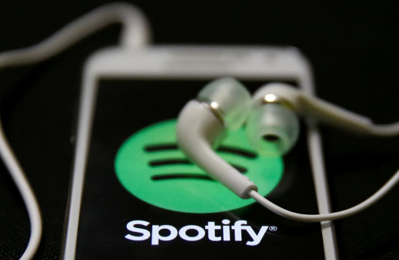 Earphones are seen on top of a smart phone with a Spotify logo on it, in Zenica February 20, 2014. (photo credit: DADO RUVIC/REUTERS)
