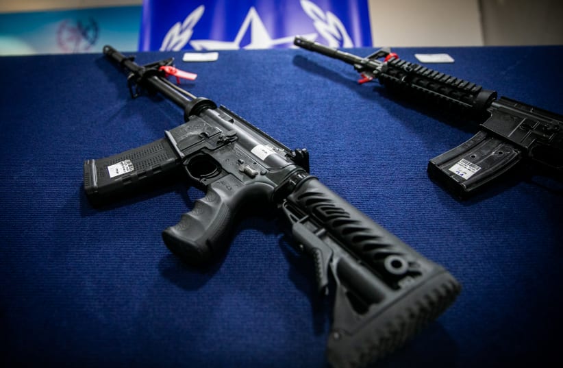  Illegal weapons are displayed during a ceremony in Ma'ale Adumim, after a large police operation against illegal gun dealers, September 7, 2022.  (photo credit: OREN BEN HAKOON/FLASH90)