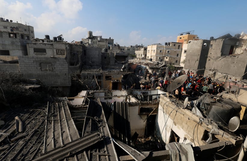  Palestinians inspect the site of Israeli strikes on houses after a temporary truce between Palestinian Islamist group Hamas and Israel expired, in Khan Younis in the southern Gaza Strip, December 1, 2023 (photo credit: REUTERS/MOHAMMED SALEM)