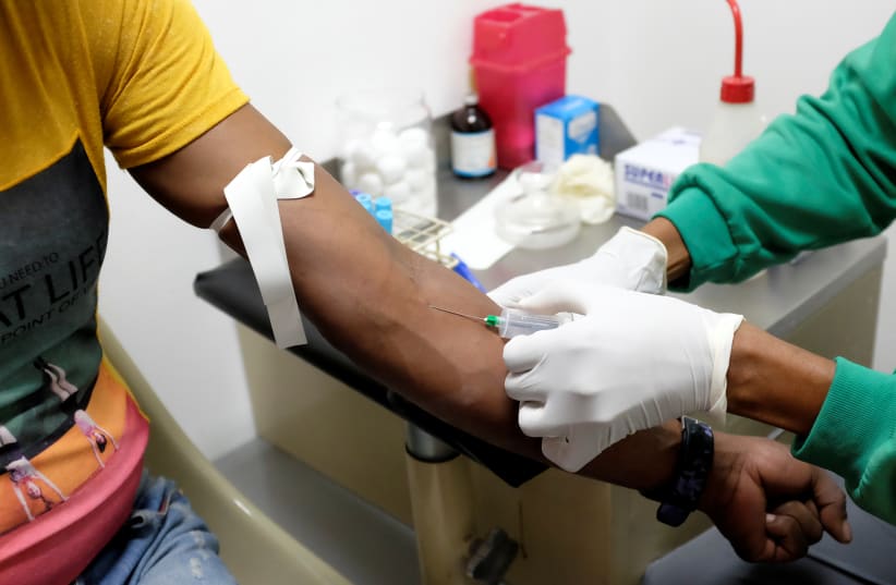  A nurse draws a blood sample for an HIV test at the lab of the NGO "Accion Solidaria" (Solidarity Action) in Caracas, Venezuela, November 28, 2018. Picture taken November 28, 2018.  (photo credit: REUTERS/MARCO BELLO)