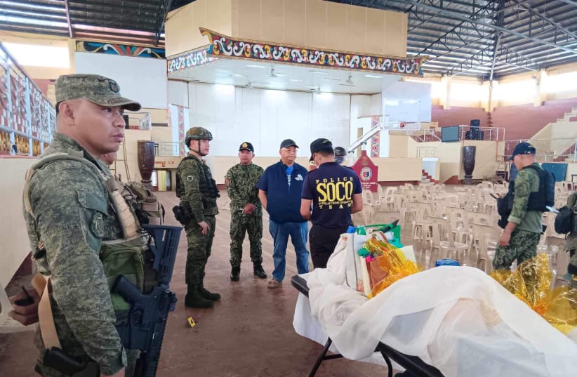 Lanao Del Sur Governor Mamintal Adiong Jr. stands among law enforcement officers as they investigate the scene of an explosion that occurred during a Catholic Mass in a gymnasium at Mindanao State University in Marawi, Philippines, December 3, 2023. (photo credit: Lanao Del Sur Provincial Government/Handout via REUTERS)