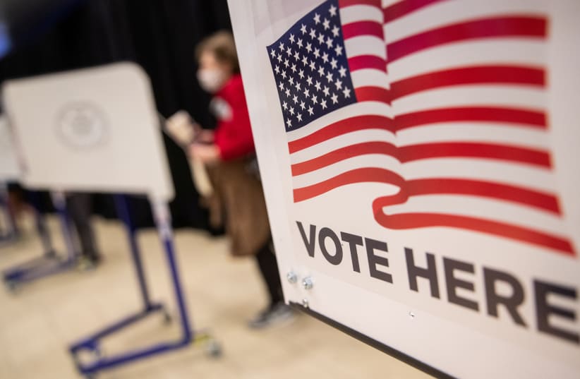  An American flag sign is seen on a voting booth at Madison Square Garden, which is used as a polling station on the first day of early voting in Manhattan, New York, U.S. October 24, 2020. (photo credit: REUTERS/JEENAH MOON)