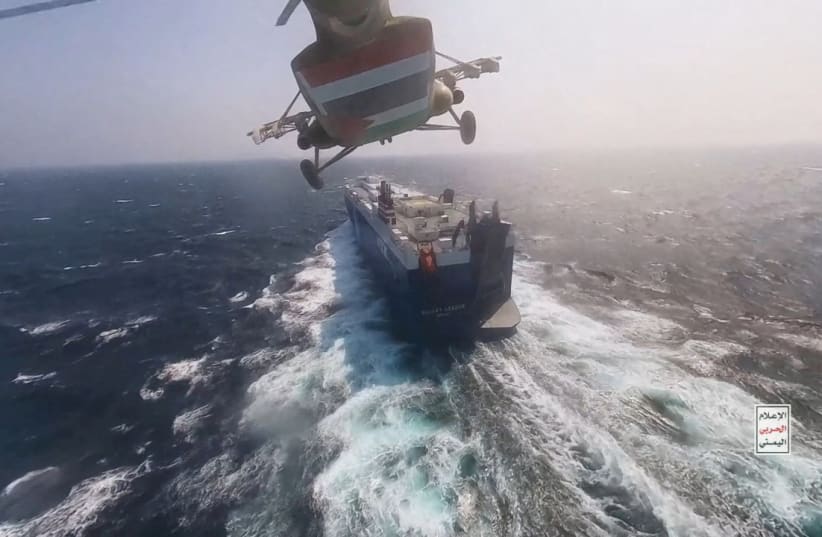  Houthi military helicopter flies over the Galaxy Leader cargo ship in the Red Sea in this photo released November 20, 2023. (photo credit: Houthi Military Media/Handout via REUTERS)