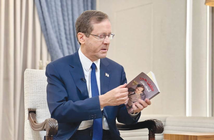  President Isaac Herzog shows an Arabic translation of ‘Mein Kampf,’ found on the body of a Hamas terrorist in Gaza.  (photo credit: PRESIDENT'S RESIDENCE)